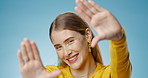 Portrait, studio and happy woman with finger frame, focus and creative photography with confidence. Perspective, hand gesture and girl showing face, casual kiss and view finder on blue background.