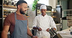 Male chef, cooking class and knife in kitchen for learn, teacher and food for professional skills. Restaurant, workshop or culinary student with sharpen tools, explain and communication for demo