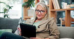 Smile, tablet and senior woman on sofa with connection, subscription or online news website in home. Scroll, internet and person on couch with reading, retirement and digital app chat in living room