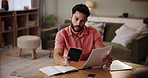 Paperwork, home and man with stress in finance for investment, budget and payment of debt. Frustrated, person and documents with calculator on table in living room for mortgage, planning and problem