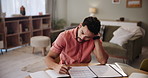 Home, documents and man with anxiety in finance for mortgage, problem or payment of debt. Frustrated, person and paperwork with stress on table in living room for budget, investment or financial risk