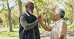 Interracial, couple and happy with high five outdoor for bonding, support or conversation in street. Mature, people or laughing in road with funny joke, comic story or walking in park for retirement 