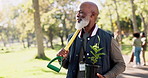 Mature, man and volunteer with plants in park for earth day, community service or sustainable ngo project. African, person or walking in nature with spade for gardening, eco friendly hobby or ecology