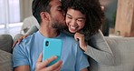 Communication, phone and video call with couple waving, talking and looking happy while having online conversation while sitting at home. Man and woman greeting with network connection on smartphone