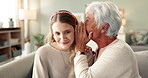 Family secret, woman and grandmother in home for whisper, gossip and talking for news on living room sofa. Quiet conversation, confidential and senior person with girl listening to private mystery