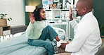 Happy doctor, child and tying shoes with high five on bed for fun checkup, consultation or healthcare at clinic. Black man or medical employee helping girl tie laces at hospital or private practice