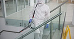 Man, hazmat suit and chemical for cleaning on stairs, pandemic and disinfection for bacteria. Male person, lockdown and spray for illness spread in office, sanitation and biohazard for virus safety