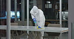 Spray, disinfect and person with hazmat suit in laboratory for germs, virus exposure or prevent infection. Biohazard, cleaning and man with ppe for decontamination, chemical or hazardous waste