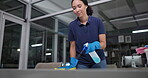 Woman, wipe and spray for cleaning counter in office, disinfection and janitor for liquid. Female person, maintenance service and chemical treatment to prevent germs, bacteria and disease at night