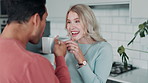 Happy couple, talking and drinking coffee in home kitchen for morning breakfast, cheers or interracial people laughing together. Man, woman and toast with tea for celebration or funny conversation