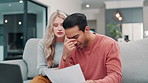 Couple, stress and home debt or financial documents for loan, mortgage and bankruptcy on laptop and sofa. People fight, argue or worry of cost of living, invoice and inflation with paperwork or bills