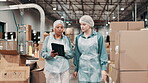 Distribution, woman and manager with tablet in factory for inspection, inventory check or shipping. Discussion, industrial and mature person with cargo employee for logistics, export or supply chain