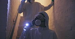 Evidence, people and scientists on search, investigation and dark in basement of house and forensic. Walking, underground and flashlight in night, ppe and safety with gas mask, hazardous and home