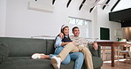 Sitting down, love and couple on sofa for watching tv, show or routine series at home for bonding. Holding hands, movie date and people in living room for television, news or streaming, video or film