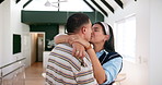 Couple, happy and kiss with hug in new home with celebration, real estate and property investment. People, embrace and excited for mortgage, dream apartment and homeowner with keys and smile in house