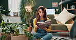 Book, gardening and plants with woman on living room floor for information, reading or research. How to, learning and study with person in home apartment for green hobby, horticulture or leisure 