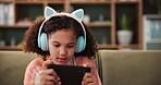 Home, girl or kid on smartphone for games, relax and streaming cartoon or movies in living room. Child, connection and tech in house with headset for watching video, playing or mobile app online