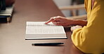 Woman, hands and reading a bible in home for worship, gratitude and information on God in living room. Christianity, person and holy book  for faith, belief and spiritual by table in lounge of house