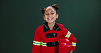 Face, firefighter and girl with smile, helmet and career ambition on dark studio background. Portrait, model or kid with uniform, child development or cheerful with joy, happiness and smile with job