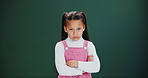 Angry, face and girl with arms crossed in studio with grumpy attitude, tantrum or challenge. Frustrated, kid and emoji of stubborn child with anger or negative mood in dark background or bully mockup