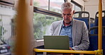 Business, mature man and travel with bus on laptop to browse internet for news update, report and current affairs with commuting to work. Public transport, email and networking with communication