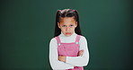 Angry, face and girl with arms crossed in studio with grumpy attitude, tantrum or conflict. Frustrated, kid and emoji of upset child with anger and negative mood in dark background or fashion mockup