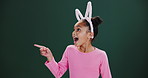 Easter, bunny and child pointing to surprise announcement, news or shock in studio mockup. Holiday, info and excited kid show crazy choice in dark background, space with fashion or costume ears