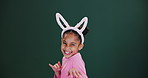 Children, face or funny girl in bunny ears in studio for fun, game or easter event or competition on green background. Happy, portrait or excited kid model in rabbit costume for birthday party theme