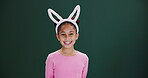 Easter, girl and face with bunny ears in studio for promotion, announcement or holiday mockup. Festival, sale and portrait of child in dark background, space for news with fashion or rabbit costume