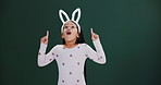 Easter, bunny and hands of child pointing to promotion, announcement in studio or mockup. Holiday, sale and excited kid show surprise info in dark background, space for news with fashion or costume