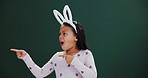 Shock, child and girl pointing with hands in studio mockup on Easter in bunny ears. Holiday, surprise and kid show crazy info in dark background, space for news with festive fashion or costume