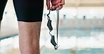Man, sport and fitness with legs and goggles at swimming pool for endurance training and exercise for race. Male person, athlete and swimwear for strength workout and practice for competition 