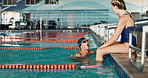 Male athlete, pool and exercise for time, partner and stopwatch for race in gym. Training, sports and professional sportsman for fitness in water workout, friend and coach for celebration for success