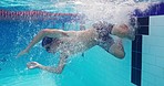 Athlete, man and swimming in water, fast and training for competition, exercise and energy for fitness. Workout, swimmer and person with speed, performance and cardio in pool, race and action
