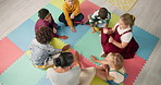 Kindergarten, children and hands with game in circle for development, growth and activity. Teacher, high angle and playful student on mat in class for sensory education, learning and creative skill