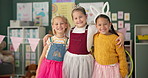 Happy girls, friends and hug with costume in class for dress up or casual day at school together. Portrait of children or kids with smile for halloween in princess outfit, tutu or fairy tale in room