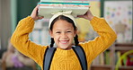 Child, face and books on head or excited for school learning or reading lesson, classroom or education. Girl, kid and portrait as youth student for academic development or knowledge, study or happy