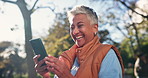 Outdoor, senior woman and cellphone with typing, online reading and social media with sunlight, app and contact. Person, nature or old lady in park, smartphone or message with email, text or smile