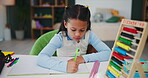 Girl, kid and drawing on book in classroom at school for education or child development. Kindergarten, creativity and art project, assignment and assessment in preschool with stationery for learning