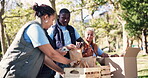 Volunteers, food box and charity in outdoors, help and community service for social responsibility. People, donation and grocery bags for society project, non profit and teamwork for accountability