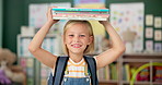 Happy, young girl and books on her head in kindergarten school for child development, growth and learning. Smile, female person or student with novel for story time with education, study and reading