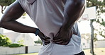 Hands, back pain and person with injury outdoor at basketball court for health exercise, fitness or training accident. Sports, spine and athlete with muscle problem, arthritis and body fibromyalgia