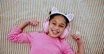 Headphones, relax and face of child on bed dancing to online music, radio or playlist at home. Happy, rest and portrait of girl kid streaming song or album on internet in bedroom at house from above.