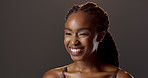 Laugh, skincare and thinking black woman in studio with natural beauty, glow and luxury cosmetics. Dermatology, facial care and happy girl with confidence, makeup and healthy skin on dark background.