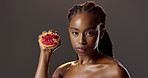 Grapefruit, skincare and portrait of black woman in studio for natural beauty, glow and cosmetics. Dermatology, fruit detox and serious girl with confidence, makeup or healthy skin on dark background