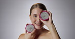 Woman, portrait and dragon fruit with smile in studio for health or face in confidence for self esteem. Immune system, vitamin c and magnesium for low iron with wellness isolated on gray background.