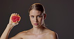 Grapefruit, skincare and portrait of woman in studio for natural beauty, vitamin c and cosmetics. Dermatology, fruit detox and serious girl with confidence, makeup or healthy skin on dark background