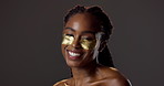 Gold, eye pad and portrait of black woman with skincare for natural beauty, product and luxury cosmetics in studio. Dermatology, smile and girl with collagen, patch or healthy skin on dark background