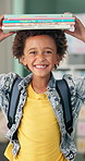 Books, education and face of child in school ready for studying, lesson and learning in classroom. Textbooks on head,  student and portrait of happy, excited and young boy for knowledge on academy