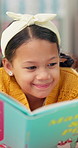 Happy girl, story and reading with book for learning, education or literature on fairy tale at library. Young female person, child or kid with smile for novel, childhood development or fantasy